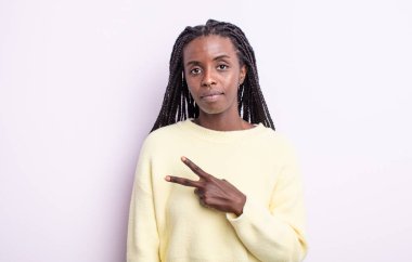 siyah güzel bir kadın mutlu, pozitif ve başarılı hissediyor, göğsünde el yapımı V ile zafer ya da barış gösteriyor.