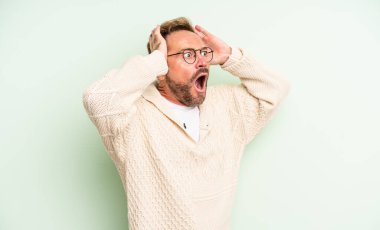 Orta yaşlı, ağzı açık yakışıklı bir adam korkunç bir hata yüzünden dehşete düşmüş ve şok olmuş görünüyor.