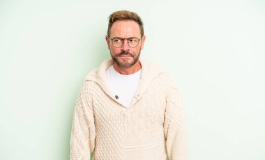 Orta yaşlı yakışıklı bir adam kafası karışmış ve kafası karışmış görünüyor. Bir sorunu çözmeye çalışıyor ya da düşünüyor.