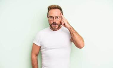 Orta yaşlı yakışıklı adam şaşırmış, ağzı açık, şok olmuş, yeni bir düşünce, fikir ya da konsept keşfediyor.