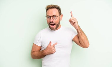 Orta yaşlı yakışıklı bir adam gururlu ve şaşırmış, kendine güvenen, kendini başarılı bir numara gibi hisseden.