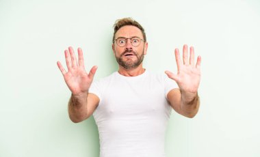 Orta yaşlı yakışıklı adam sersemlemiş ve korkmuş hissediyor. Korkutucu bir şeyden korkuyor. Elleri açık ve uzak dur diyor.