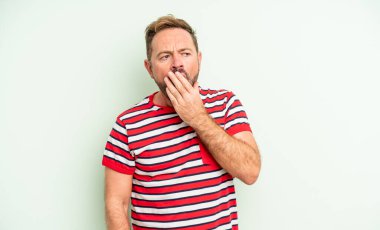 Orta yaşlı yakışıklı adam sabahın erken saatlerinde uyanıyor, uykulu, yorgun ve sıkkın görünüyor.