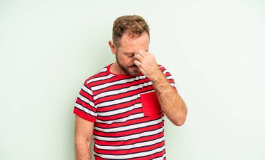 Orta yaşlı yakışıklı, stresli, mutsuz ve hayal kırıklığına uğramış, alınlı ve şiddetli baş ağrısı çeken bir adam.