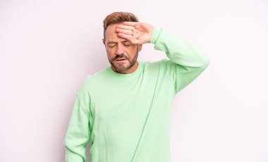 Orta yaşlı yakışıklı, stresli, yorgun ve hayal kırıklığına uğramış, alnından ter damlayan, umutsuz ve bitkin hisseden bir adam.