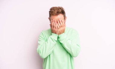 Orta yaşlı, yakışıklı, üzgün, sinirli ve depresif bir adam. İki eliyle yüzünü kapatıyor, ağlıyor.