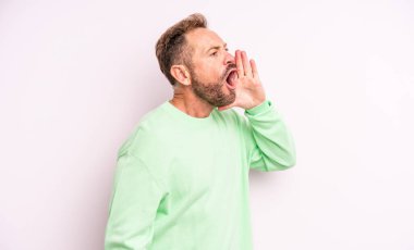 Orta yaşlı yakışıklı adam profili, mutlu ve heyecanlı görünüyor, bağırıyor ve bir yandan da fotokopi için arıyor.