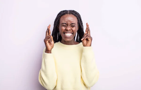 Mujer Bonita Negra Sonriendo Ansiosamente Cruzando Ambos Dedos Sintiéndose Preocupada —  Fotos de Stock