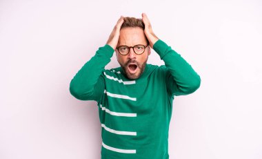 Orta yaşlı, yakışıklı, dehşete kapılmış ve şok olmuş hisseden, el ele tutuşan ve hata yaptığında panikleyen bir adam.