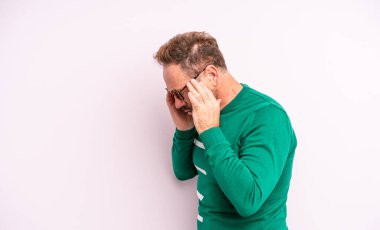 Orta yaşlı, yakışıklı, üzgün, hayal kırıklığına uğramış bakışları, ağlamaları, yan bakışları olan elleri olan bir adam.