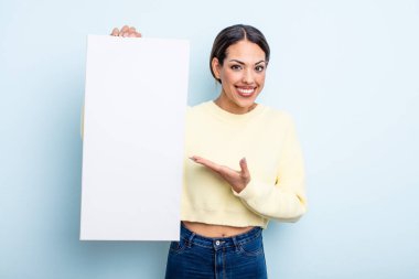 Güzel İspanyol bir kadın neşeli bir şekilde gülümsüyor, mutlu hissediyor ve bir konsept gösteriyor. boş alan kavramı