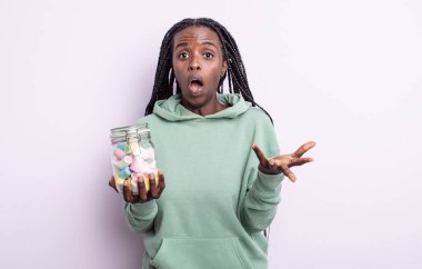 Güzel siyah kadın çok şaşırmış ve şok olmuş hissediyor. jöle şekeri konsepti