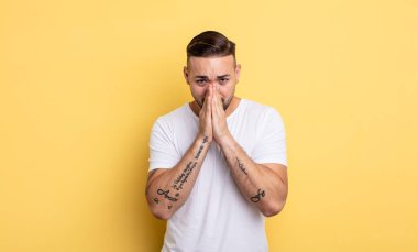 Genç, yakışıklı, endişeli, umutlu ve dindar bir adam. Avuçlarına bastırılmış, af dileyen sadık bir şekilde dua ediyor.