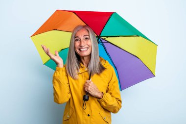 Orta yaşlı beyaz saçlı kadın mutlu hissediyordu. Bir çözüm ya da fikir bulduğuna şaşırmıştı. şemsiye ve yağmur kavramı