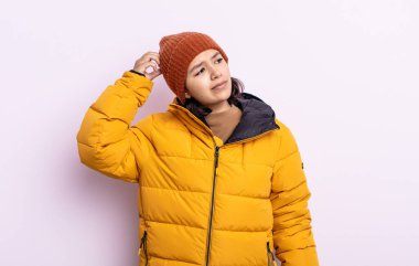 Güzel genç bayan mutlu bir şekilde gülümsüyor ve hayal kuruyor ya da şüphe ediyor. Soğuk hava kavramı