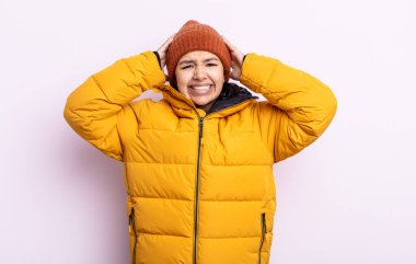 Güzel genç bir kadın stresli, endişeli ya da korkmuş hissediyor. Elleri başının üstünde. Soğuk hava kavramı