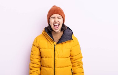 Güzel genç bir kadın agresif bir şekilde bağırıyor, çok kızgın görünüyor. Soğuk hava kavramı