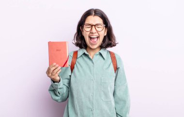 Güzel genç bir kadın agresif bir şekilde bağırıyor, çok kızgın görünüyor. 2022 ajanda kavramı