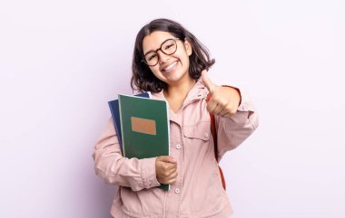 Güzel genç bir bayan gururlu, olumlu gülümsüyor. Kitap konsepti olan öğrenci