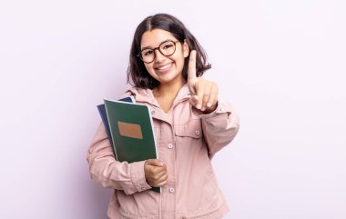 Güzel genç bayan gururla gülümsüyor ve kendinden emin bir numara oluyor. Kitap konsepti olan öğrenci