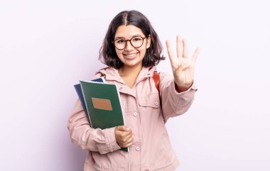 Güzel genç bayan gülümsüyor ve arkadaş canlısı görünüyor, dört numarayı gösteriyor. Kitap konsepti olan öğrenci