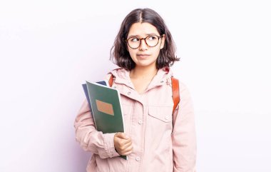 Güzel genç bir kadın üzgün, üzgün ya da kızgın hissediyor ve yan tarafa bakıyor. Kitap konsepti olan öğrenci