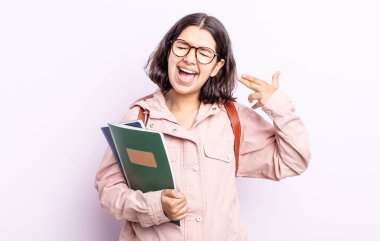 Güzel, genç bir kadın mutsuz ve stresli görünüyor, intihar jesti silah işareti yapıyor. Kitap konsepti olan öğrenci