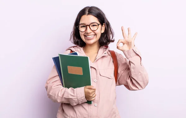 漂亮的年轻女子感到快乐 以好的姿态表示赞同 具有图书概念的学生 — 图库照片