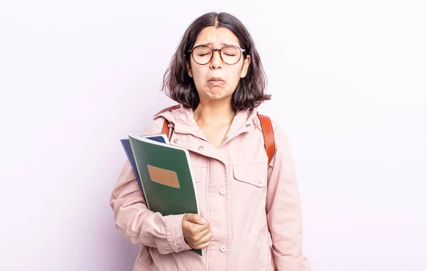 不幸な表情で泣いたり泣いたりする若い女性です 本のコンセプトを持つ学生は — ストック写真