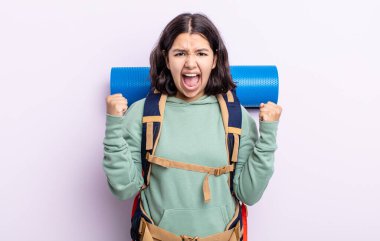 Güzel genç bir kadın sinirli bir ifadeyle agresif bir şekilde bağırıyor. yürüyüş kavramı