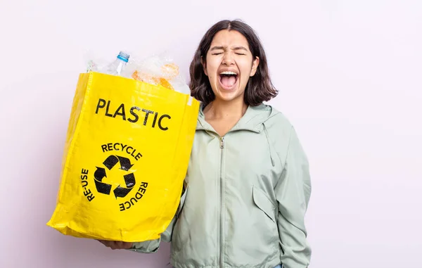 若い女性が積極的に叫んでとても怒っているように見えます プラスチックリサイクルの概念 — ストック写真
