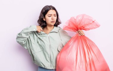 Güzel genç bir kadın stresli, endişeli, yorgun ve hayal kırıklığına uğramış hissediyor. Çöp torbası kavramı