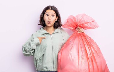 Şok olmuş ve ağzı açık, kendini işaret eden güzel genç bir kadın. Çöp torbası kavramı