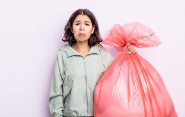 Güzel, genç bir kadın üzgün ve mızmızlanıyor. Mutsuz bir bakışı var ve ağlıyor. Çöp torbası kavramı