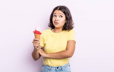 Güzel genç bir kadın omuz silkiyor, kafası karışık ve kararsız hissediyor. dondurma konsepti