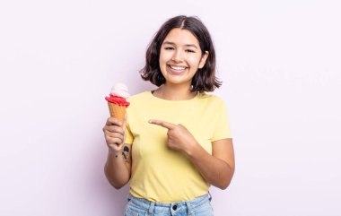 Güzel, genç bir bayan neşeyle gülümsüyor, mutlu hissediyor ve bir tarafı işaret ediyor. dondurma konsepti