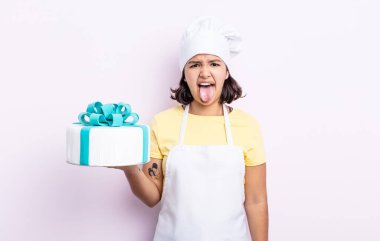 Güzel, genç bir kadın iğreniyor, sinirleniyor ve dilini çıkarıyor. Şef kek pişiriyor.