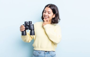 Güzel, genç bir kadın, mutlu ve kendinden emin bir ifadeyle gülümsüyor. dürbün kavramı