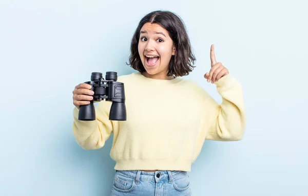 漂亮的年轻女人在意识到自己的想法后 觉得自己是个快乐而又兴奋的天才 双筒望远镜概念 — 图库照片