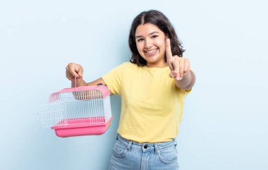 Güzel genç bayan gururla gülümsüyor ve kendinden emin bir numara oluyor. evcil hayvan kafesi