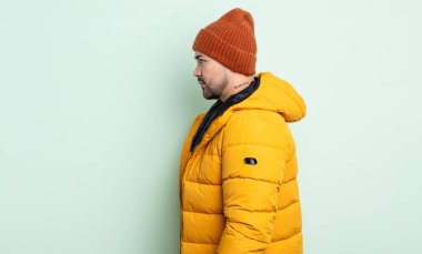 Profilde genç yakışıklı bir adam hayal kuruyor, hayal kuruyor ya da hayal kuruyor. Soğuk hava kavramı