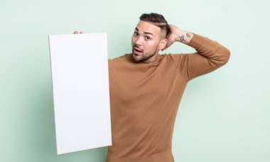 Genç ve yakışıklı bir adam stresli, endişeli ya da korkmuş hissediyor. Elleri başının üstünde. boş tuval kavramı