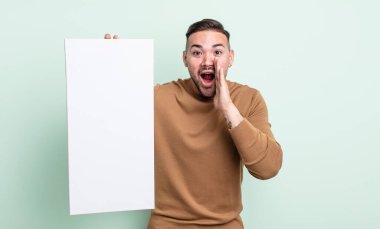 Genç yakışıklı adam mutlu hissediyor, elleri ağzının kenarında bağırıyor. boş tuval kavramı