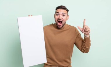 Genç yakışıklı bir adam bir fikri fark ettikten sonra mutlu ve heyecanlı bir dahi gibi hissediyor. boş tuval kavramı