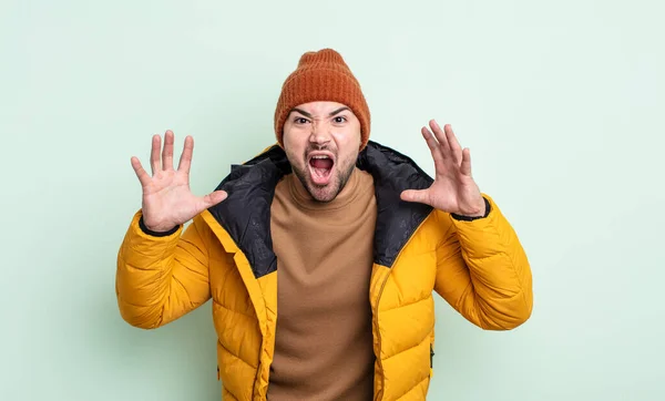 若いハンサムな男が手を上げて叫んでる 寒い気候の概念 — ストック写真
