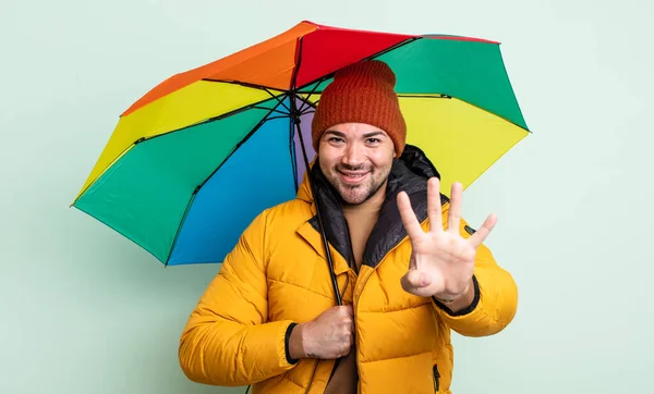 Jonge Knappe Man Glimlachend Vriendelijk Toont Nummer Vier Regen Overkoepelend — Stockfoto