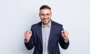 Genç yakışıklı adam şok olmuş hissediyor, gülüyor ve başarıyı kutluyor. İş adamı konsepti