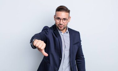 Genç ve yakışıklı bir adam kendini kötü hissediyor, baş parmağını kaldırıyor. İş adamı konsepti