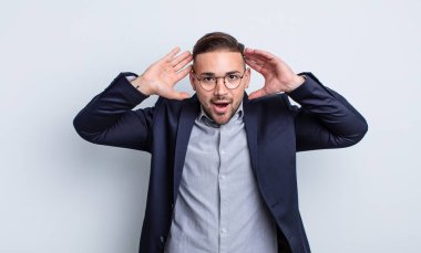 Genç ve yakışıklı bir adam stresli, endişeli ya da korkmuş hissediyor. Elleri başının üstünde. İş adamı konsepti