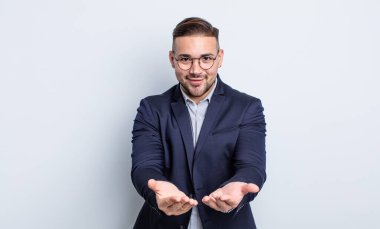 Genç ve yakışıklı bir adam arkadaşça gülümsüyor ve bir konsept sunuyor. İş adamı konsepti